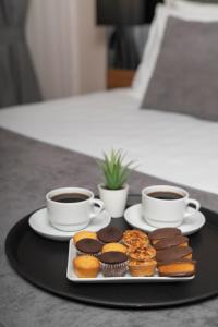 due tazze di caffè e un vassoio di muffin e cupcake di Depiero Hotel Karaköy a Istanbul
