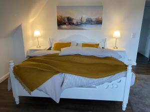 1 dormitorio con 1 cama blanca y 2 lámparas en Apartments-Bocholt, en Bocholt