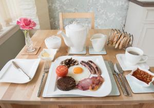 a plate of breakfast food on a wooden table at The Roses B&B in Portree