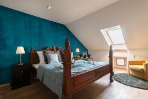 a bedroom with a bed and a blue wall at 5BD Duplex - Billiard - Home Cinema - Central in Prague
