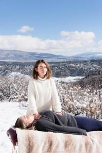 dos mujeres sentadas en una manta en la nieve en Wanderer Studio, AN OFF GRID MOUNTAIN Guest Studio With Fantastic Views, en Glenwood Springs