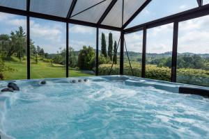 a jacuzzi tub in a room with windows at Agriturismo Corte Benedetto in Montecarlo