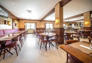 a dining room with wooden tables and chairs at Flat 305 - Gramado in Gramado