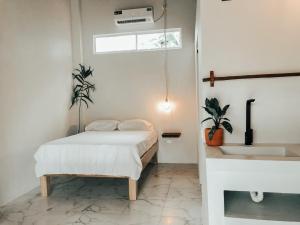 a white bedroom with a bed and a sink at Ayampe Lofts in Ayampe