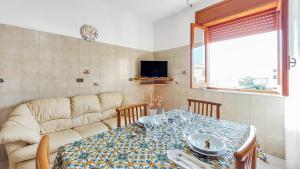 een woonkamer met een tafel en een bank bij Casetta Orchidea A pochi passi dal Centro in Lampedusa