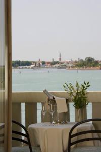 a table with wine glasses and a view of the water at Viktoria Palace Hotel in Venice-Lido