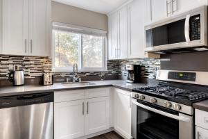 San Mateo studio w pool wd nr 20 restaurants SFO-1148 في سان ماتيو: مطبخ بخزائن بيضاء وفرن موقد