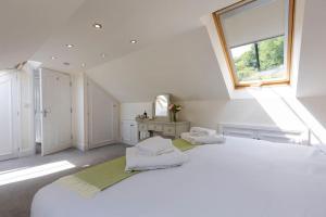 a large white bedroom with two beds and a window at The Lemon Grove, Leyburn in Leyburn