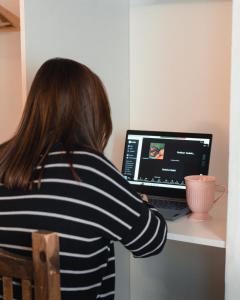 a woman sitting at a desk with a laptop computer at Chepatagonia Hostel & Experiences in Puerto Madryn