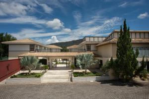 a large building with palm trees in front of it at Don Quixote Pousada in Tiradentes