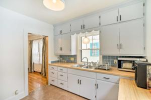 eine Küche mit weißen Schränken und einem Waschbecken in der Unterkunft Minneapolis Vacation Rental Near Lake Harriet in Minneapolis