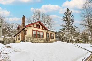 ein Haus mit einem Kamin auf einem Schneehaufen in der Unterkunft Minneapolis Vacation Rental Near Lake Harriet in Minneapolis