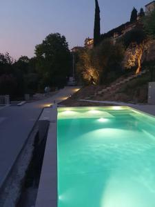a swimming pool with lights on the side of a road at Villa Malù - APT Luisa Piscina e vista lago in Torri del Benaco