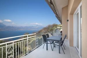 a balcony with a table and chairs and a view of the water at Villa Malù - APT Luisa Piscina e vista lago in Torri del Benaco