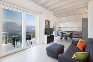 a living room with a couch and a large window at Villa Malù - APT Luisa Piscina e vista lago in Torri del Benaco