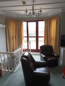 a living room with a couch and chairs and a window at Eden Vale Garden View Apartment with Patio in Morecambe