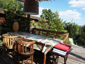 een houten tafel en stoelen op een terras met een tafel bij Riesling Stein Home in Mittelbergheim