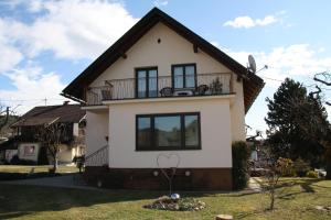 a house with a balcony on top of it at Haus Sonnental Velden am Wörthersee in Velden am Wörthersee