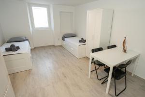 a room with two beds and a desk and a table at Ricky Apartments in Novalja