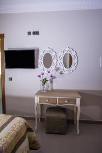 a bedroom with a table with two mirrors on the wall at Hotel Bajamar Centro in Nerja