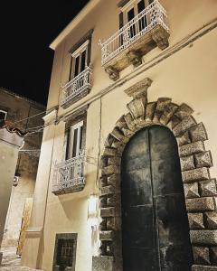 ein Gebäude mit einer Tür, einem Fenster und einem Balkon in der Unterkunft B&B Costa degli Dei in Tropea