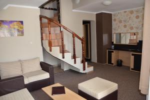 a living room with a couch and a staircase at Olymp Hotel in Bansko