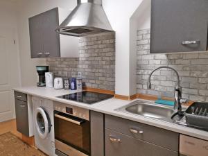 a kitchen with a sink and a washing machine at Musashi Apartment 1 in Weimar