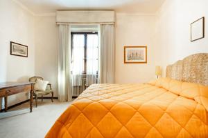 1 dormitorio con 1 cama grande de color naranja y escritorio en Il Poggiolino - Tuscan villa located in Chianti's hills, en Badia A Passignano