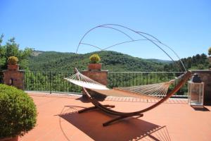 una hamaca en un patio con montañas al fondo en Il Poggiolino - Tuscan villa located in Chianti's hills, en Badia A Passignano