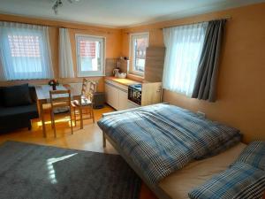 a bedroom with a bed and a kitchen with a table at zentrale & ruhige Ferienwohnung in Mössingen