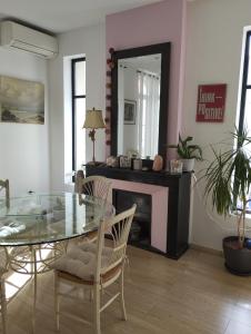 comedor con mesa de cristal y chimenea en Bel appartement privatif en Perpiñán