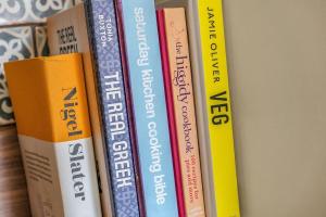 un groupe de livres assis sur une étagère dans l'établissement Stylish country home near East Linton and Edinburgh, à Whittingehame