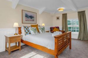 um quarto com uma grande cama de madeira e uma janela em Stylish country home near East Linton and Edinburgh em Whittingehame