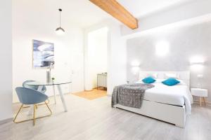 Dormitorio blanco con cama y mesa en Trastevere Silver King JacuzziSuite -TopCollection, en Roma
