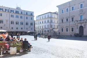 un grupo de personas sentadas en una calle con edificios en Trastevere Silver King JacuzziSuite -TopCollection, en Roma