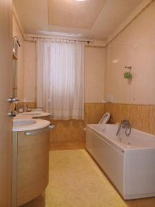a bathroom with a tub and a sink and a bath tub at CASAVACANZE MEVANIA in Bevagna