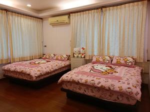 a bedroom with two beds with hello kitty sheets at Kamiyamato B&B in Guangfu