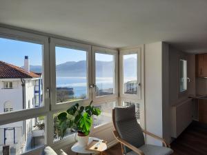 a room with large windows with a chair and a plant at APARTAMENTOS ARATUSTE - News a estrenar in Mundaka