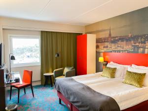 um quarto de hotel com uma cama grande e uma secretária em ProfilHotels Nacka em Estocolmo