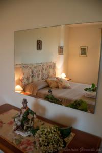 - un miroir suspendu au-dessus d'un lit dans une chambre dans l'établissement Appartamento per Vacanze Domus Lunae, à Luni