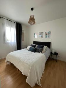 a bedroom with a large bed and a window at Ty kalon in Carantec