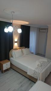 a bedroom with a large white bed and a table at Ali's Pension in Egirdir