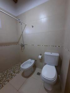 een witte badkamer met een toilet en een bidet bij Finca Los Racimos - Casa Syrah in San Rafael +55 foto's