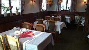 a dining room with tables and chairs and windows at Pension Zur Sonne Wittenweier in Schwanau