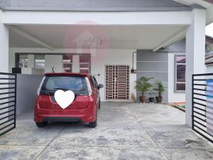 a red car with a heart painted on it parked in a garage at AfiRA Homestay Cherating in Kuantan
