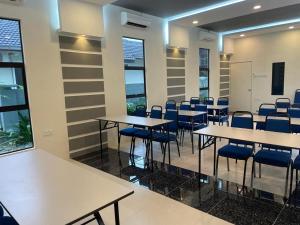 Cette chambre comprend des tables, des chaises et des fenêtres. dans l'établissement Villa Motel Mas Guesthouse, à Batang Berjuntai