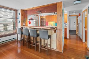 a kitchen with a bar with four stools at Bridge View Suite by Iris Properties! in Victoria