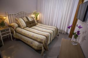 a bedroom with a bed and a table and a tv at Hotel Bajamar Centro in Nerja