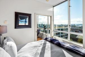 een slaapkamer met een bed en een groot raam bij Corazon Vista by Iris Properties! in Victoria