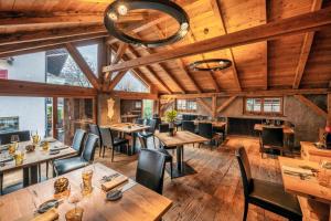 un ristorante con soffitti in legno, tavoli e sedie di Stadele a Lana